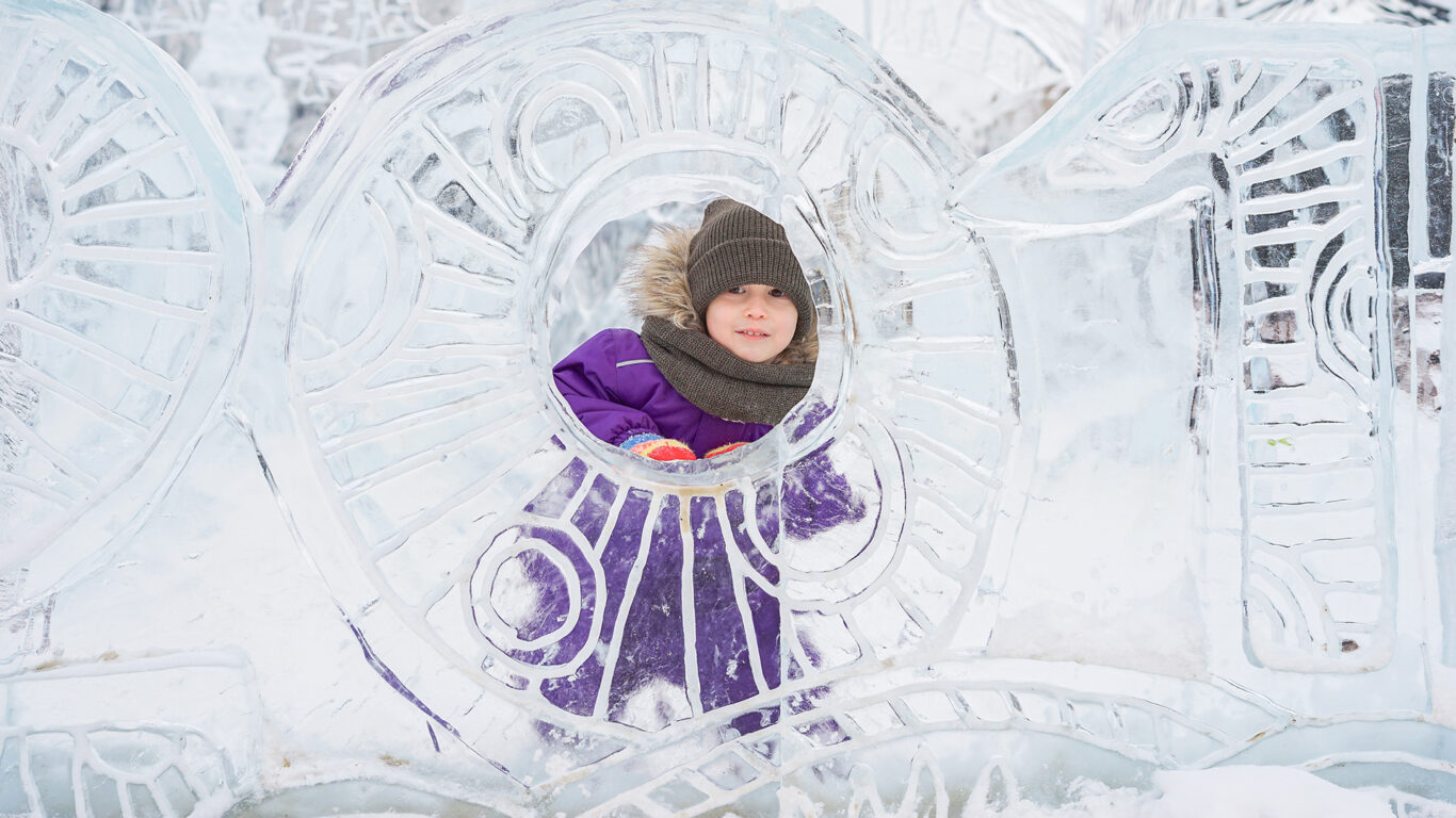 Boy hiding behind an ice sculpture